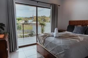 1 dormitorio con cama y ventana grande en Private home with resort style swimming pool, en Jacó