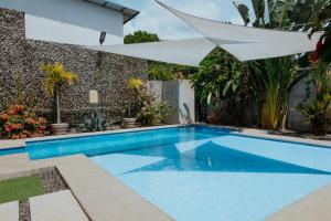 雅各的住宿－Private home with resort style swimming pool，院子里的带白色遮阳伞的游泳池