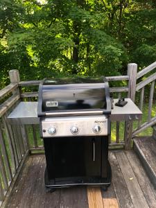 a barbecue grill sitting on a wooden bench at Rustic Lakefront Cottage Derby Paddles Lodge in Derby Center