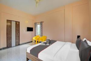 ThākurdwariにあるArhan Villa Inn Kolkata - Excellent Customer Choice - Best Sellerのベッドルーム1室(ベッド1台、黄色い椅子2脚付)