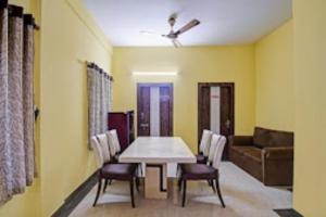 uma sala de jantar com uma mesa e cadeiras e um sofá em Arhan Villa Inn Kolkata em Thākurdwari