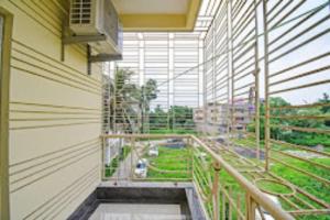 einen Balkon eines Gebäudes mit Straßenblick in der Unterkunft Arhan Villa Inn Kolkata - Excellent Customer Choice - Best Seller in Thākurdwari