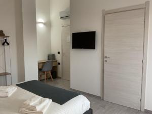 1 dormitorio con puerta y TV en la pared en Climy en Sestu