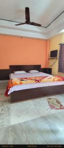 a bedroom with a large bed with an orange wall at India Tours only Ekanta Apan in Mathurakhanga