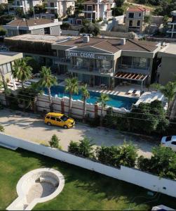 une voiture jaune garée devant un bâtiment avec piscine dans l'établissement SEREN OTEL ÇEŞME, à Çeşme