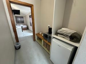a small room with a refrigerator and a bedroom at Southernwood nest in East London