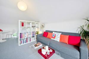 Zone 1! 2 bed duplex Apartment! في لندن: غرفة معيشة مع أريكة ورف كتاب