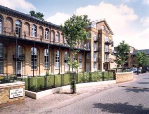 a building with a fence and a tree in front of it at Zone 1! 2 bed duplex Apartment! in London