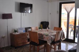 a dining room with a table and chairs and a television at APARTAMENTO 3 PAUPÍ in Oliva