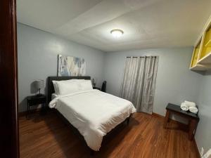 1 dormitorio con 1 cama grande con sábanas blancas en Comfy getaway at falls!, en Niagara Falls