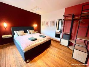 um quarto com uma cama grande e uma parede vermelha em Le Loft liégeois - Au coeur de la cité em Liège