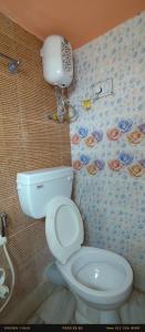 a bathroom with a toilet and a phone on the wall at India Tours only Ekanta Apan in Mathurakhanga