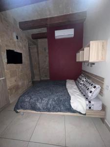 ein Schlafzimmer mit einem Bett in einem Zimmer in der Unterkunft Twenty Antika in Vittoriosa