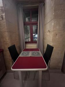 a table and chairs in a room with a window at Twenty Antika in Birgu +18 photos