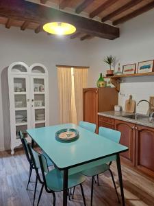 a kitchen with a blue table and chairs at casa il Girasole Pitigliano in Pitigliano