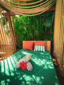 Una cama con dos almohadas y una flor. en Kawan Bay Suites en Deshaies