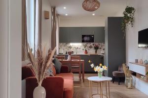 a living room with a couch and a table and a kitchen at L'Instant Vert in Clermont-Ferrand