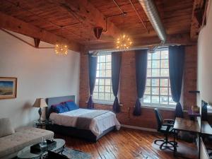 - une chambre avec un lit dans une pièce dotée de fenêtres dans l'établissement Detroit Artsy Industrial Loft, à Detroit