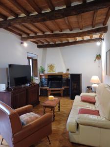 sala de estar con sofá y TV de pantalla plana en casa il Girasole Pitigliano, en Pitigliano