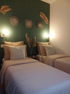 - une chambre avec 2 lits et un mur vert dans l'établissement Maison cosy terrasse ensoleillé, à Clermont-Ferrand