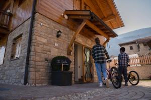 two men standing outside of a building with a bike at Agritur La Crucola in Flavon