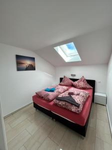 una camera da letto con un letto con lenzuola rosa e una finestra di Ferienwohnung Familie Sobierajczyk - Fewo unweit Ostsee a Blankenhagen