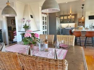 a dining room with a table with flowers on it at Lysekil sunset Villa in Lysekil