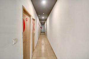 un largo pasillo con una pared blanca y una puerta blanca en OYO Flagship JPS Grand Hotel, en Nueva Delhi