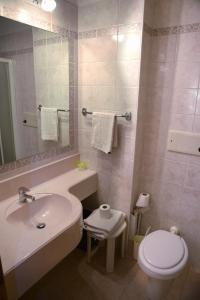 a white bathroom with a sink and a toilet at Hostel San Matteo in Santa Caterina Valfurva