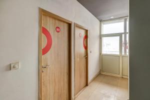 un couloir avec une porte en bois et une fenêtre dans l'établissement OYO Flagship JPS Grand Hotel, à New Delhi