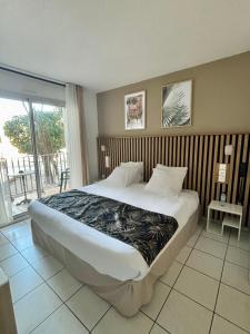 1 dormitorio con 1 cama grande y balcón en Acapella Hotel, en Argelès-sur-Mer