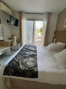 a hotel room with a large bed and a balcony at Acapella Hotel in Argelès-sur-Mer