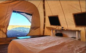 a bedroom with a tent with a bed and a tv at Kestrel in Valle