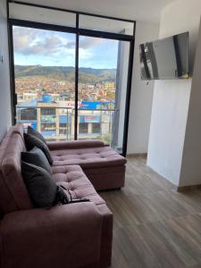 a person laying on a couch in a room with a large window at Apartamento CHAMPA PASTO in Pasto