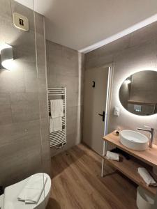 ein Badezimmer mit Toilette, Waschbecken und Spiegel in der Unterkunft Acapella Hotel Restaurant in Argelès-sur-Mer