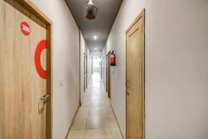 un couloir avec deux portes et un long couloir dans l'établissement OYO Flagship JPS Grand Hotel, à New Delhi