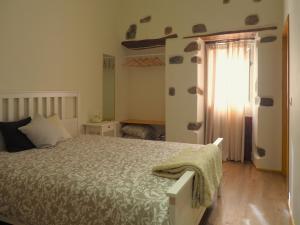 a bedroom with a large bed and a window at Casa da Venda do Marco in Caldas da Rainha