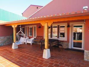 eine Terrasse mit Markise und Stühlen auf einem Haus in der Unterkunft Casa da Venda do Marco in Caldas da Rainha