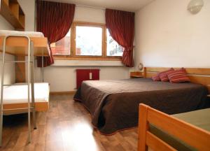 ein Schlafzimmer mit einem Bett und einem Etagenbett in der Unterkunft Hostel San Matteo in Santa Caterina Valfurva