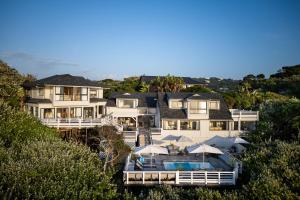 une grande maison blanche avec une piscine en face de celle-ci dans l'établissement Prana Lodge, à Chintsa