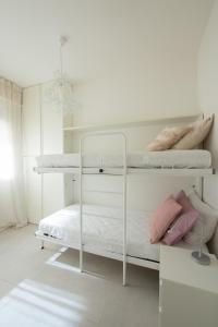 een witte slaapkamer met 2 stapelbedden en een kroonluchter bij VIRGINIA APPARTAMENTI RICCIONE in Riccione