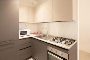 een keuken met een spoelbak en een magnetron bij VIRGINIA APPARTAMENTI RICCIONE in Riccione +1 foto