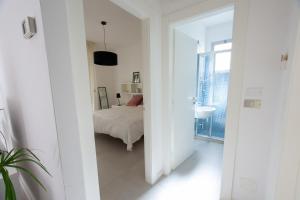 een witte kamer met een bed en een badkamer bij VIRGINIA APPARTAMENTI RICCIONE in Riccione