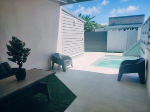 d'une terrasse avec un banc et des chaises à côté de la piscine. dans l'établissement Archipel Maimeo, à Saint-François