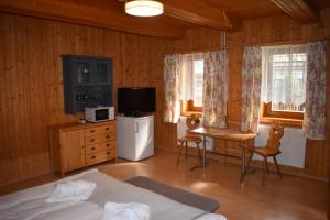 a bedroom with a bed and a tv and a table at Drevenica Diana in Ždiar