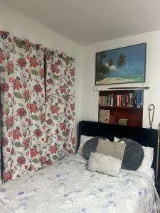 a bedroom with a bed with floral curtains at Charming Studio Flat Near Center City in Philadelphia