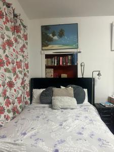 a bedroom with a bed and a tv on the wall at Charming Studio Flat Near Center City in Philadelphia