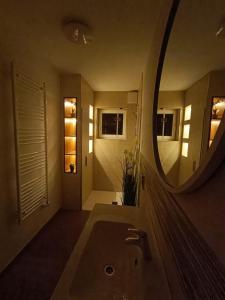 ein Badezimmer mit einem großen Spiegel und einem Waschbecken in der Unterkunft Apartma Kapitanovše in Ajdovščina