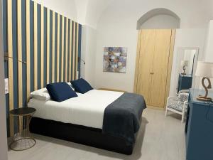 a bedroom with a large bed with blue pillows at Apartamento Las Bóvedas in Cáceres