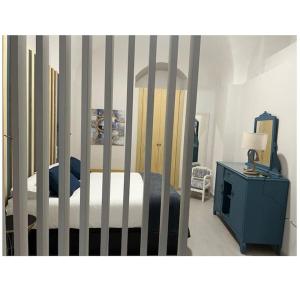 a bedroom with a crib and a blue cabinet with a bed at Apartamento Las Bóvedas in Cáceres